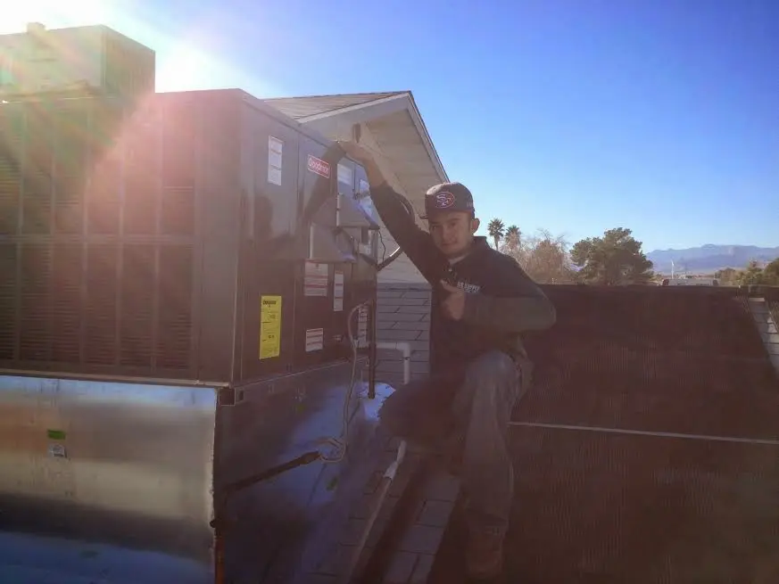 HVAC technician performing HVAC Inspection on a rooftop unit in Casper